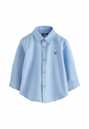 Hellblaues Hemd mit langen Ärmeln aus glattem Stoff. Es verfügt über Holzknöpfe und ein kleines Bärenlogo auf der Brust.