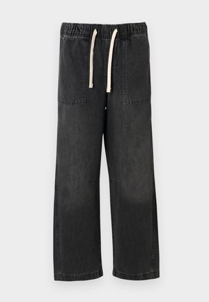 Čierne džínsy s voľným strihom, elastickým pásom a krémovým sťahovacím šnúrkou, dvoma prednými vreckami a viditeľnými švami.