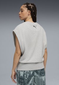 Gray sleeveless sweatshirt with a round neckline, made of soft fabric. Features a small black Puma logo at the back, relaxed fit.