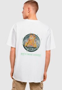 Hvid bomulds t-shirt med et cirkulært flammegrafik med dollartegn og teksten "LID IKKE PÅ NOGEN" i grøn nedenfor.