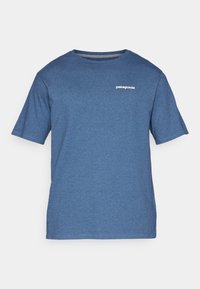 Modrá tričko s krátkým rukávem vyrobené z jemného materiálu. Má kulatý výstřih a malé bílé logo Patagonia na levé části hrudníku.