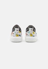 Zapatillas con un diseño gráfico colorido que presenta ilustraciones de estilo cómic sobre una suela blanca texturizada y una sección superior negra.