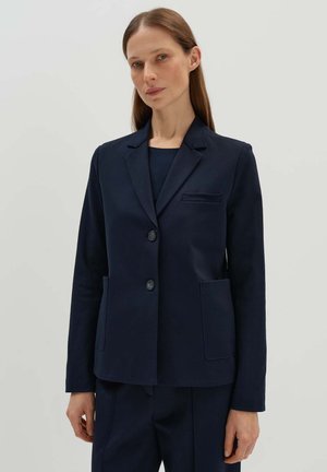 Marineblazer aus glattem Stoff, mit Reverskragen, zwei Vordertaschen und zwei Knöpfen. Schlichtes, tailliertes Design.