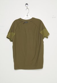 Chemise à manches courtes vert olive avec des patchs vert clair sur les manches, accrochée à un cintre en plastique transparent sur fond blanc.