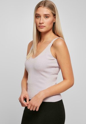 Heledad lillakas ribaga kaelusega tank top, millel on õhukesed õlapaelad, koos musta lähedalt lõigatud seelikuga, mis näitab tekstuurseid mustreid.