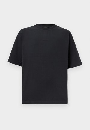 Zwart oversized T-shirt met korte mouwen en ronde halslijn, met subtiele reliëftekst op de borst, weergegeven tegen een effen witte achtergrond.