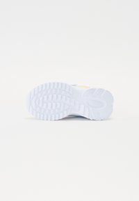 Suola di sneaker bianca con una presa testurizzata e decorata. Presenta un accento multicolore vicino al tallone, un materiale liscio e durevole.