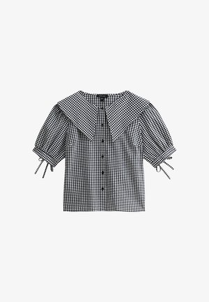 Czarna i biała bluzka w kratę z krótkim rękawem, z dużym kołnierzem, guzikami z przodu i akcentami związanymi na rękawach. Teksturowany materiał.