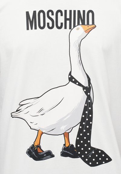 Valge T-särk, millel on joonistus hani kohta, kes kannab musti kingi ja musta täpilise lipsu. "Moschino" logo paksus mustas kirjas ülal.