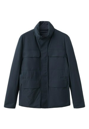 Tummansininen miesten takki, jossa korkea kaulus, etuvetoketju ja neljä läppätaskua, esitelty valkoisella taustalla.