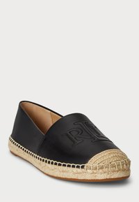 Fekete bőr espadrille, szőtt juta talppal, lekerekített orral és a felső részen dombornyomott logó részlettel. A sima textúra kontrasztban áll a szőtt díszítéssel.