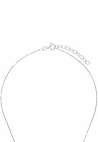 Sterlingsilverhalsband med en tunn, platt kedja, som har en spänne och en justerbar förlängningskedja för längdvariation.