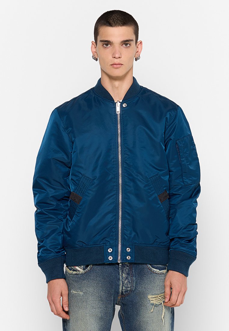 Veste bomber bleu marine en satin brillant, avec des poignets côtelés, une fermeture éclair à l'avant et des poches latérales avec des accents noirs.