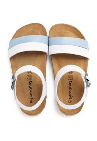 White and light blue sandals with a cork footbed, adjustable ankle strap, flat sole, and a smooth leather upper, featuring subtle branding.
