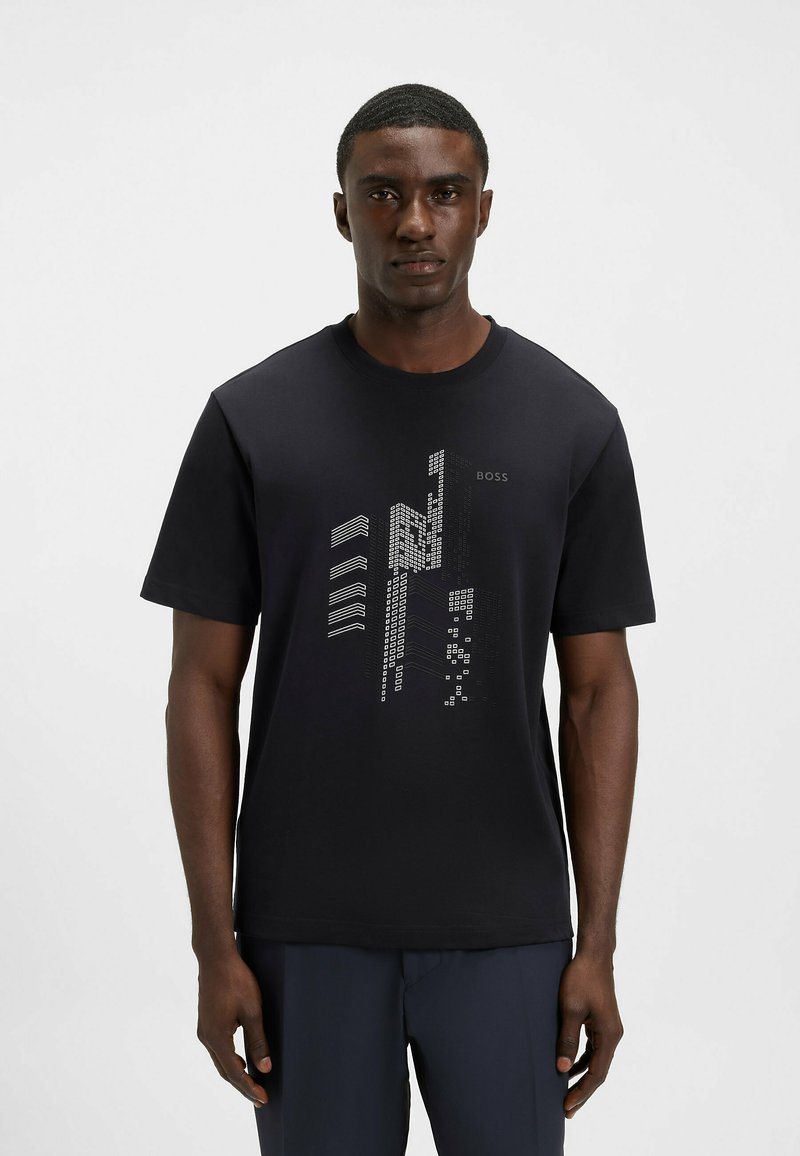 Black cotton t-shirt with short sleeves, featuring a printed geometric design in white, including text "BOSS." Crew neck style, regular fit.