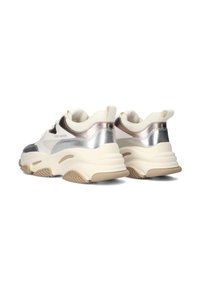 Chunky witte sneakers met zilveren accenten en een beige zool, voorzien van een merklabel. De schoenen worden vanuit de achterkant in een hoek bekeken.