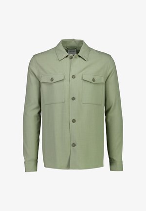 Lichtgroene blouse-jas met lange mouwen, knoopsluiting aan de voorkant, twee borstzakken met kleppen en knopen, en een puntige kraag.