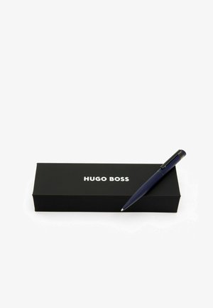 Blue ballpoint pen on a black box featuring "HUGO BOSS" printed in white. The pen has a smooth finish with a clip and rounded tip.