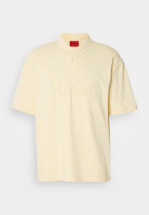 Polo shirt jaune pâle en coton au toucher doux, doté d'un col, de deux boutons et d'un grand logo "HUGO" ton sur ton à l'avant.