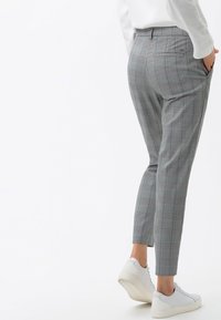 Grå rutiga byxor med slim fit-design, som har sidofickor, ett midjeband och subtila blå detaljer. Bärs med vita sneakers.