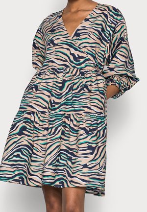 Loose-fit tiered dress with multicolor abstract zebra stripes, V-neckline, and elbow-length puff sleeves on a standing person.