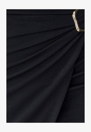 Tela negra con textura suave y diseño drapeado, que presenta pliegues y un detalle de hebilla dorada para el cierre.