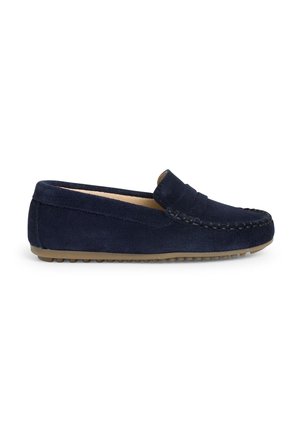 Mocassin en daim bleu marine avec coutures décoratives et semelle en caoutchouc marron clair, vu de côté sur fond blanc.