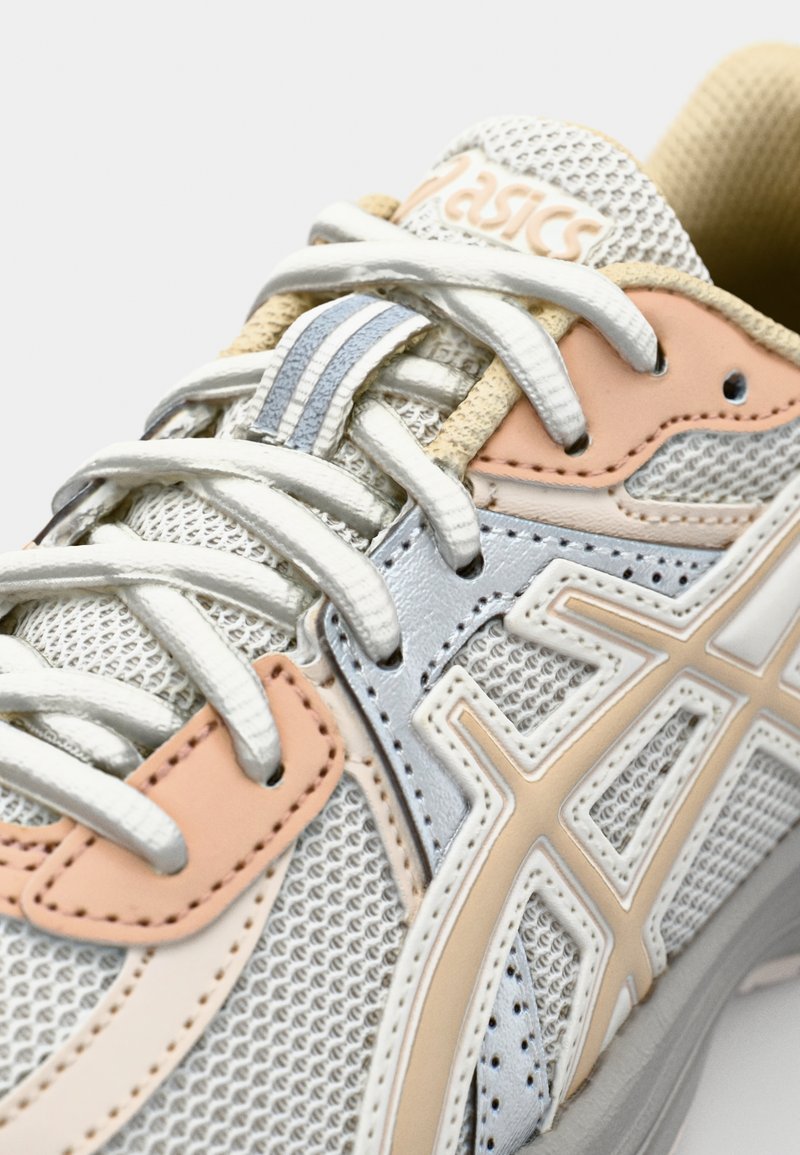 Scarpa da ginnastica con tomaia in rete bianca, accentuata da dettagli in rosa chiaro e argento. Presenta lacci a contrasto e un collo imbottito.