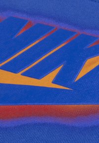 Blå stof med et stort Nike-logo, der har orange og gule accenter. Teksturen ser glat ud med en gradient baggrund.