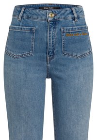 Light blue denim jeans with a high waistband, five pockets, and gold button detail. Features embroidered text "Rebel with a Smile" on the back.