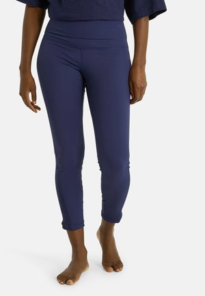 Pantalon de yoga bleu marine en tissu extensible, avec taille haute et longueur raccourcie, agrémenté d'accents texturés sur les côtés.