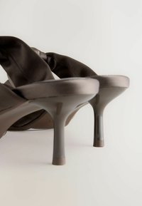 Braune Satin-High-Heelsandalen mit glatter Oberfläche und dünnem, transparentem Absatz. Auffälliges, drapiertes Stoffdetail an der Vorderseite.