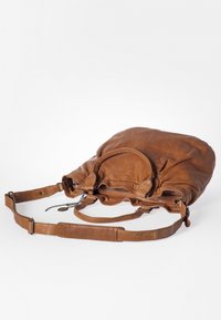 Borsa a tracolla in pelle marrone con una texture morbida, parte superiore rotonda, chiusura con zip, tracolla regolabile e dettaglio a catena. Presenta una maniglia e un logo sulla tracolla.