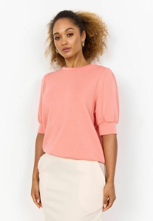 Roze, kort mouwtop met een ronde halslijn en pofmouwen, gecombineerd met een crèmekleurige, strakke rok met een rucheszakdetail.