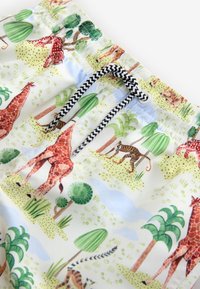Zwemshorts met een lichtblauwe achtergrond en een levendig dierenpatroon met giraffen en tijgers, en een zwart-wit aantrekkoord.
