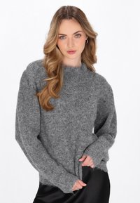Grijze gebreide trui met een zachte, textuur uitstraling, ronde halslijn en lange mouwen. De zoom heeft rafelige randen voor een casual look.