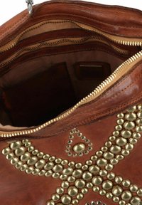 Borsa a tracolla in pelle di un ricco color marrone, con borchie dorate disposte in un motivo decorativo e un interno con zip dotato di più tasche.