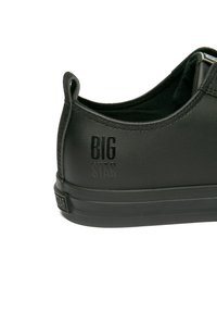 Must suured musta nahast tennisekingad on tekstuurse viimistlusega, mis asuvad mustal kummitaldadel. "BIG STAR" logo on embossitud kandadel.