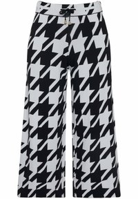 Zwart-witte wijde broek met een hounds-tooth patroon, gemaakt van een gestructureerd materiaal met een elastische tailleband en een trekkoord.