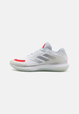Sport sneakers featuring a white mesh upper with grey accents and red detailing, a rounded toe, and a translucent rubber sole.