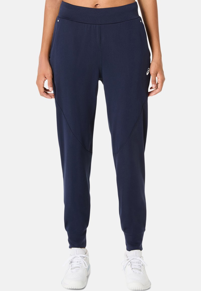 Marineblauwe sportbroek van zachte, rekbare stof met taps tolopende pijpen, zijzakken en een brede elastische tailleband.