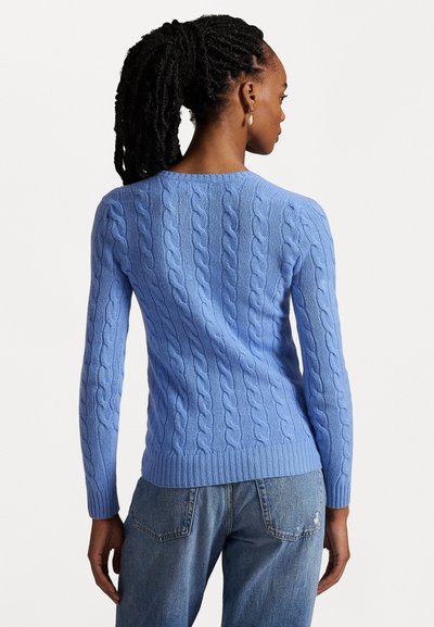 Lichtblauwe kabelgebreide trui met geribbelde onderkant en mouwen. Heeft een klassieke ronde halslijn en een gestructureerd design. Gemaakt in combinatie met casual jeans.
