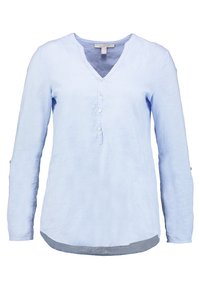 Helles blaues Langarmhemd aus Leinen, mit V-Ausschnitt, Knopfverschluss mit fünf Knöpfen und abgerundetem Saum, der hinten etwas länger ist.