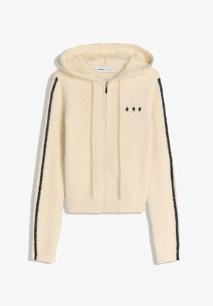 Romige fuzzy zip-up hoodie met zwarte sterborduring op de borst en zwarte strepen die langs de mouwen lopen.