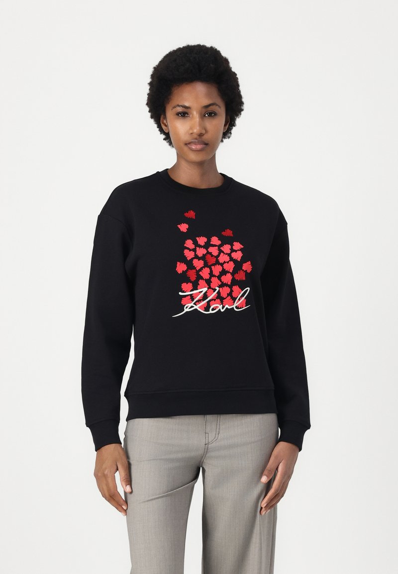 Sweatshirt preto com gráficos de corações vermelhos e "Karl" escrito em branco. Feito de uma mistura de algodão, com gola redonda e mangas longas.