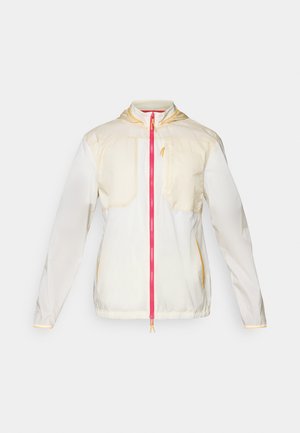 Lichtgewicht, crèmekleurige jas met een roze ritssluiting aan de voorkant, met twee borstzakken, elastische manchetten en een capuchon. Gele accenten op de naden.