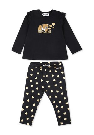 Completo nero in due pezzi che comprende una maglia a maniche lunghe con dettagli in volants, grafica di un orso dorato e leggings abbinati con motivi a cuore dorati.