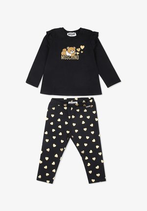 Completo nero in due pezzi che comprende una maglia a maniche lunghe con dettagli in volants, grafica di un orso dorato e leggings abbinati con motivi a cuore dorati.
