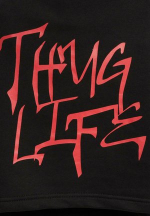 Black fabric with bold, stylized red lettering saying "Thug Life." The design features sharp angles and a textured finish.