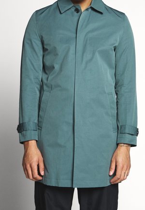 Cappotto impermeabile verde acqua con taglio dritto, colletto con bottoni, tasche laterali e polsi regolabili, caratterizzato da una texture liscia e opaca.